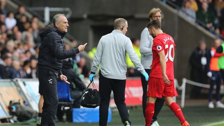 Liverpool and England midfielder Adam Lallana goes off injured in the first half