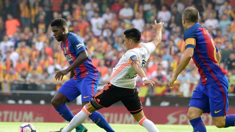 Barcelona defender Samuel Umtiti (L) vies with Valencia midfielder Enzo Perez (C) 