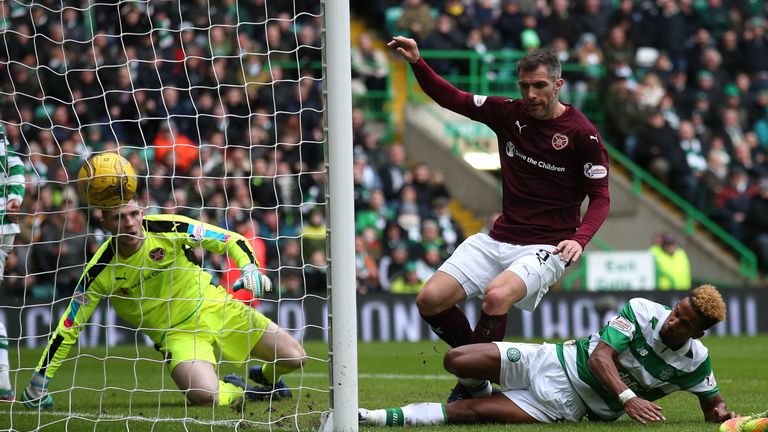 Sinclair slides in ahead of Aaron Hughes to score the second goal at Celtic Park