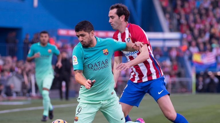 Luis Suarez (left) vies with Atletico's Diego Godin