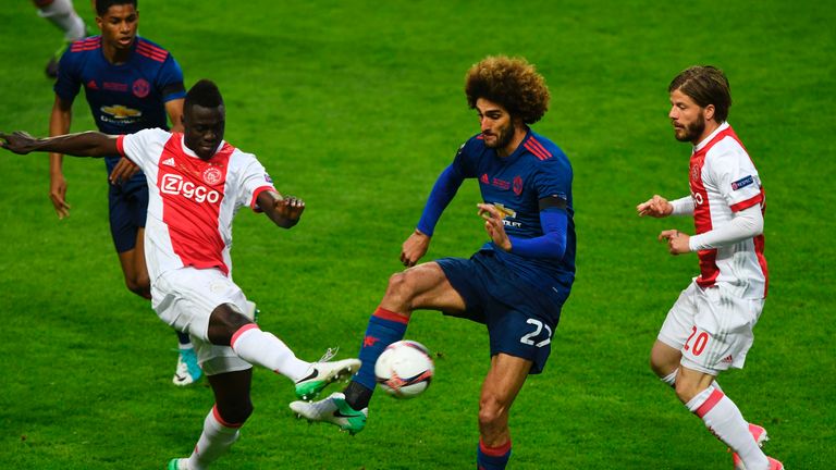 Ajax pair Davinson Sanchez (L) and Lasse Schone (R) vie for the ball with Marouane Fellaini (C)