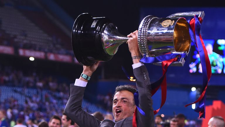 Barcelona's departing coach Luis Enrique holds up the cup
