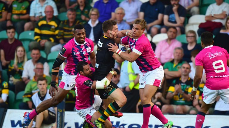 George North is tackled by Stade Francais duo Geoffrey Doumayrou and Jules Plisson (right)