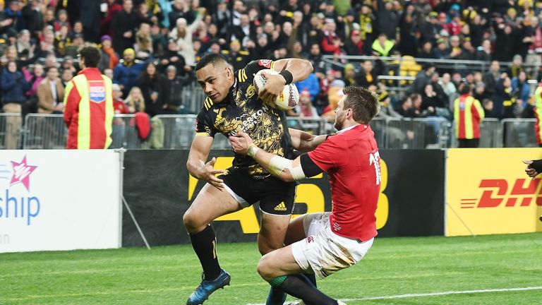 Ngani Laumape of the Hurricanes breaks a tackle by Dan Biggar
