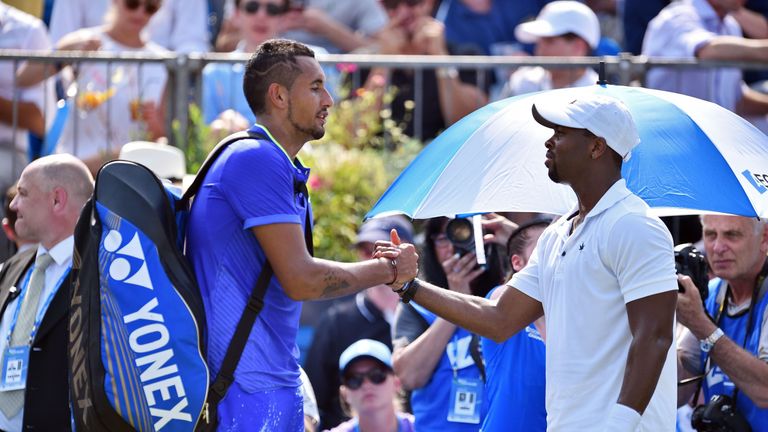 Nick Kyrgios (L) shakes hands with Donald Young of the US after having to retire