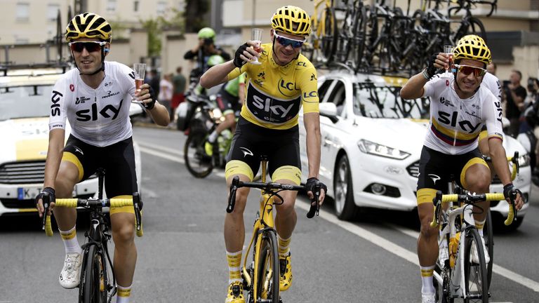   Froome, wearing the leader's yellow jersey, celebrates victory with a glbad of champagne 