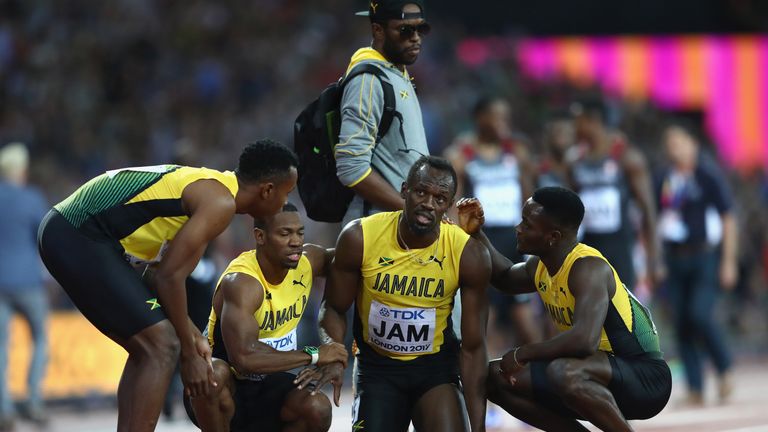 Bolt is helped up by his Jamaica team-mates