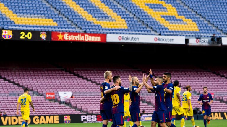 Lionel Messi celebrates with team-mates inside an empty Nou Camp against Las Palmas