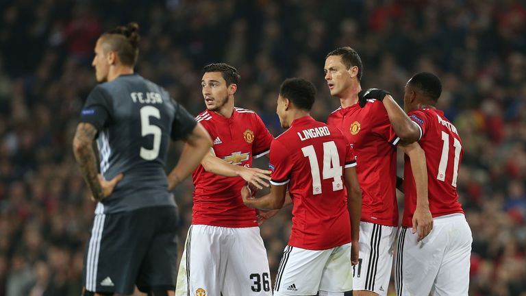 Manchester United players celebrate after taking the lead against Benfica through Mile Svilar's own goal