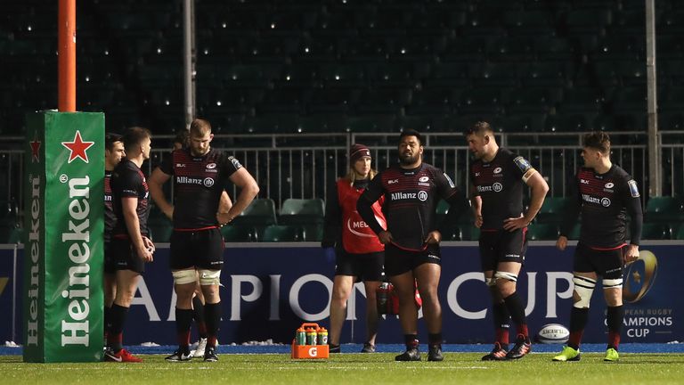 Saracens players look dejected as they stand behind the posts
