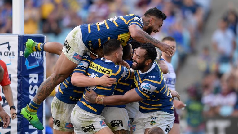 Clinton Gutherson of the Eels celebrates scoring a try with team mates
