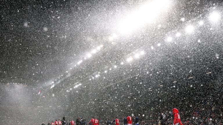 Manchester United and Brighton players walk out into heavy snow before the Emirates FA Cup, quarter-final match at Old Trafford