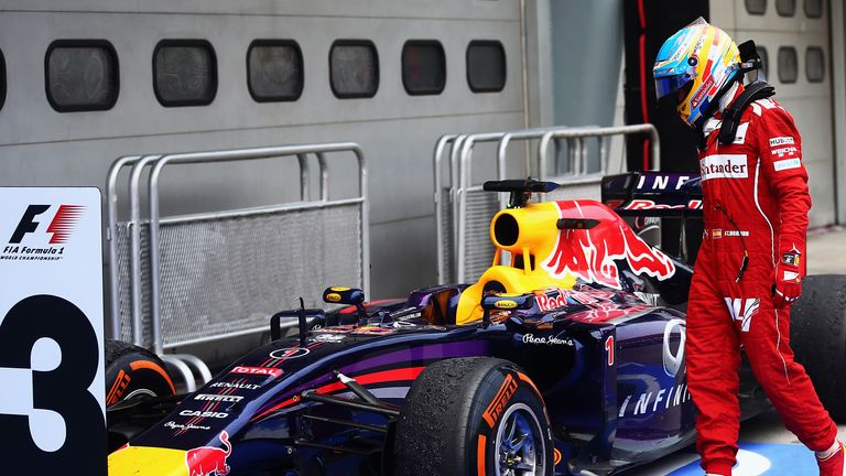 Fernando Alonso inspects the car of Sebastian Vettel