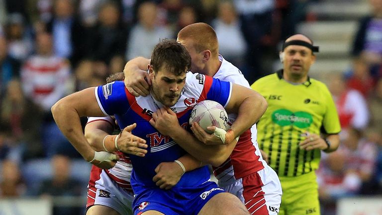 St Helens' Alex Walmsley is tackled by Wigan Warriors' Jack Hughes