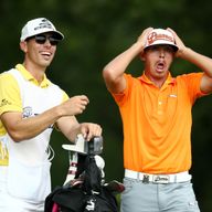 Rickie Fowler (R) of the United States reacts on the fifth tee as caddie Joseph Skovron (L) looks on during the final round of the PGA Championship