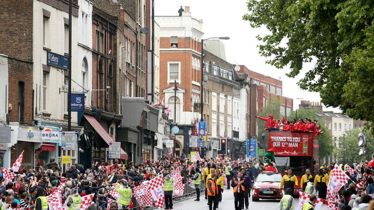 Arsenal's victory parade bus makes its way down Upper Street in Islington as fans brave the rain.