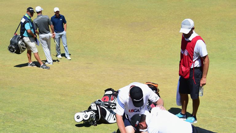 Jason Day is tended to by caddie Colin Swatton