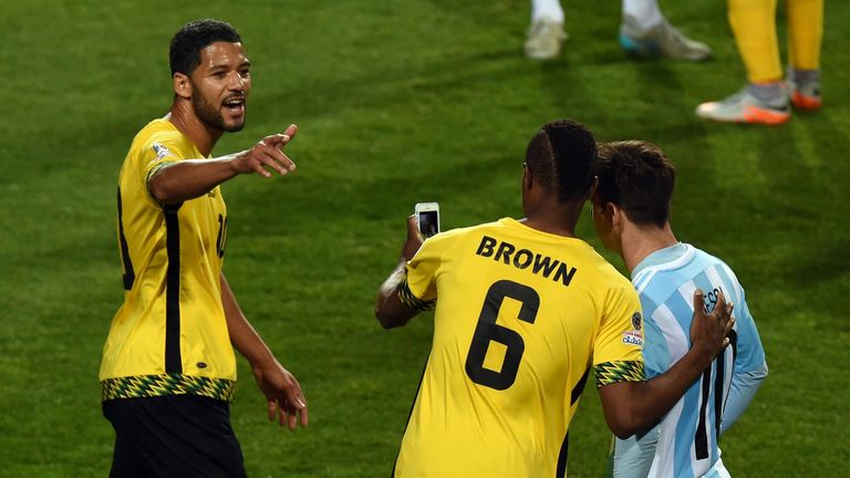 DeShorn Brown (C) poses for a selfie with Lionel Messi (R)
