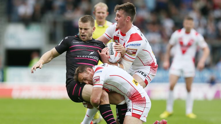 Rhys Hanbury is tackled by James Roby and St Helens Joe Greenwood