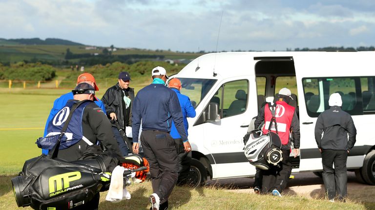 Tiger Woods, Jason Day and Louis Oosthuizen walk off the 13th green as play is suspended due to high winds