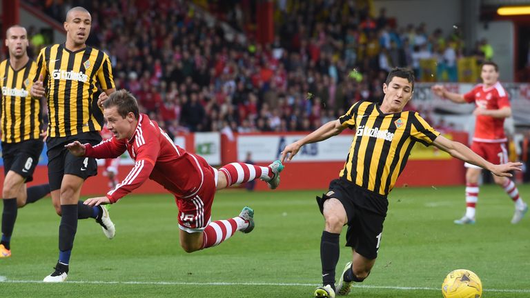 Aberdeen's Peter Pawlett (left) falls under a challenge from Kairat's Yermek Kuantayev (right)