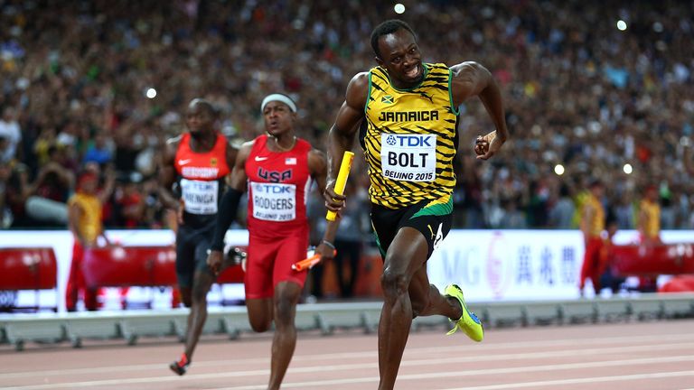 Usain Bolt of Jamaica (right) crosses the finish line to claim gold ahead of Mike Rodgers (middle) before the USA team was disqualified