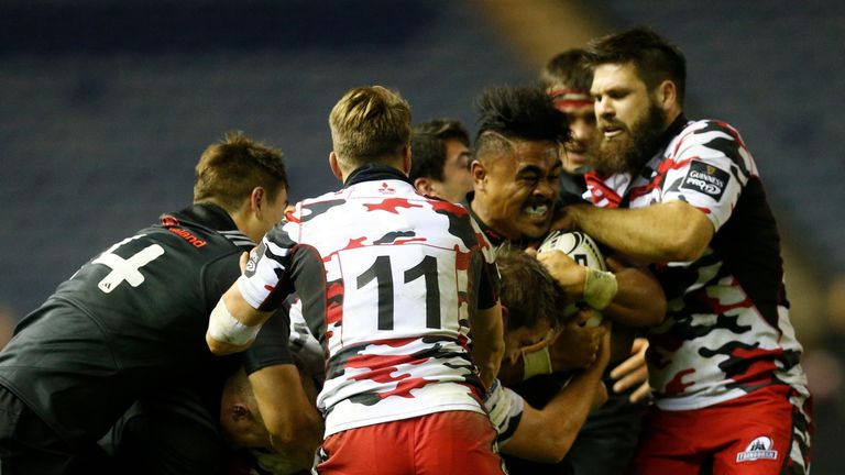 Munster's Francis Saili grapples with Tom Brown and Cornell du Preez of Edinburgh