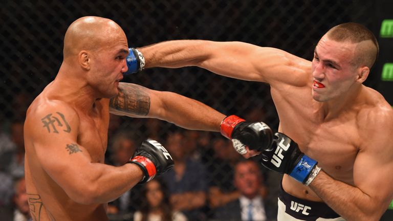 Rory MacDonald (right) strikes Robbie Lawler