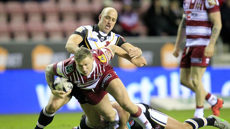 Wigan tryscorer Dom Manfredi is tackled by Michael Dobson and Tommy Lee
