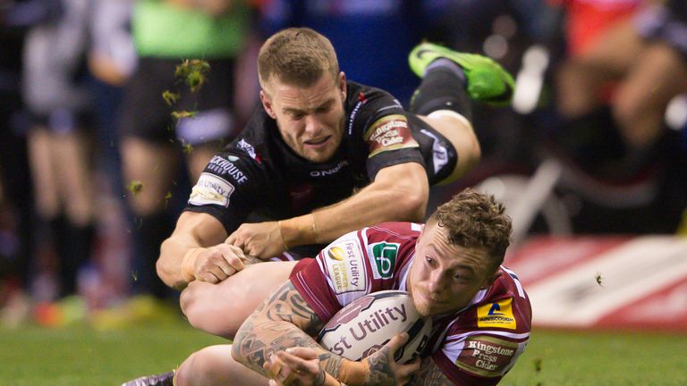 Wigan's Josh Charnley is brought down by Widnes' Rhys Hanbury.