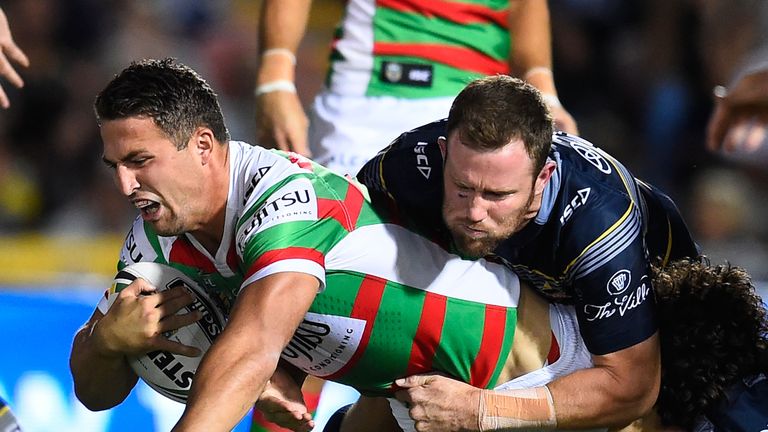 Sam Burgess of the Rabbitohs is tackled by Gavin Cooper and Jake Granville of the Cowboys