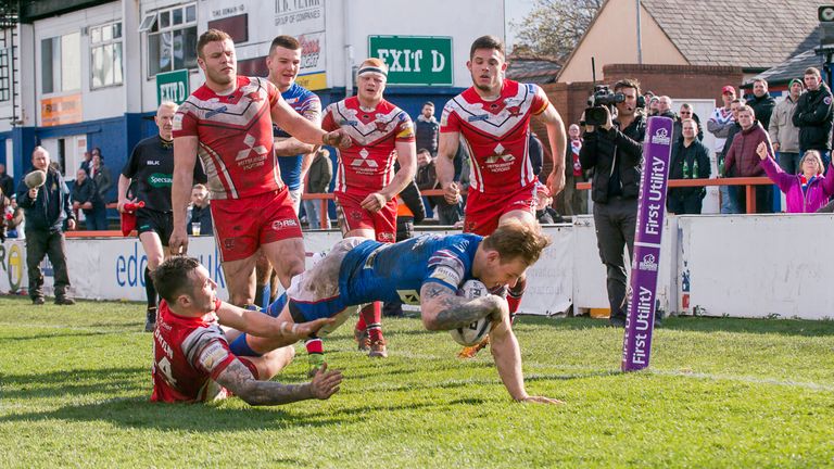 Wakefield's Tom Johnstone fights through Gareth O'Brien's tackle to score against Salford