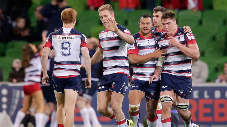Rebels players celebrate a try against Force