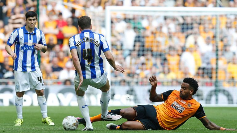 Hull City midfielder Tom Huddlestone tackles Sheffield Wednesday defender Sam Hutchinson (2L)