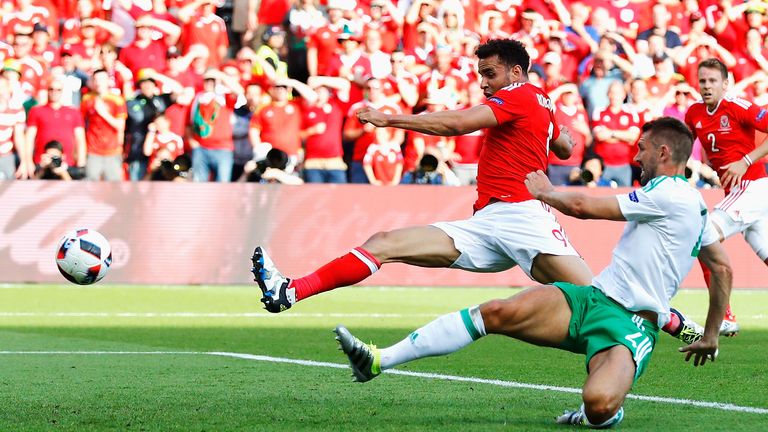 Northern Ireland's Gareth McAuley (front) can only divert a cross from Wales' Gareth Bale into his own net