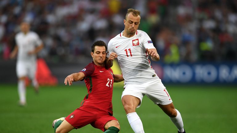 Kamil Grosicki of Poland (right) is tackled by Portugal's Cedric Soares