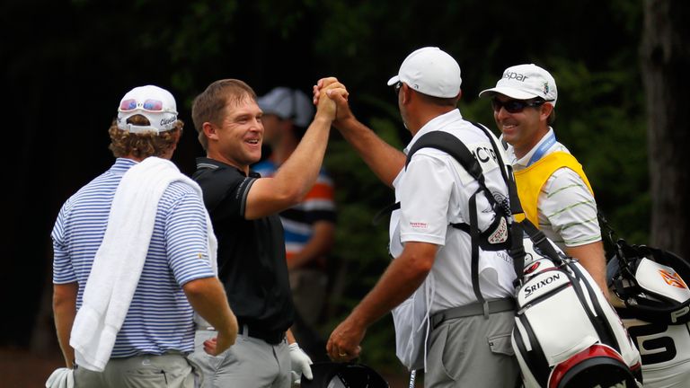 Daniel Summerhays celebrates with his caddie after holing his second from 126 yards