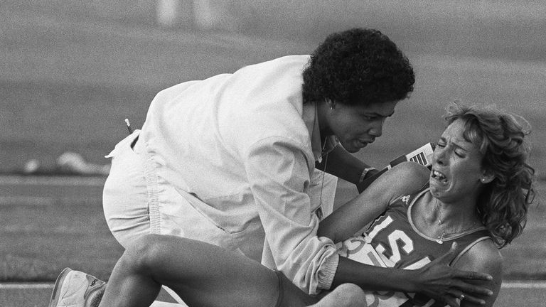 Decker is comforted by a track official after falling during the 3000m final