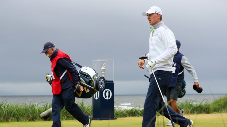 Spieth walks past the Claret Jug on the 1st tee with his caddie Michael Greller