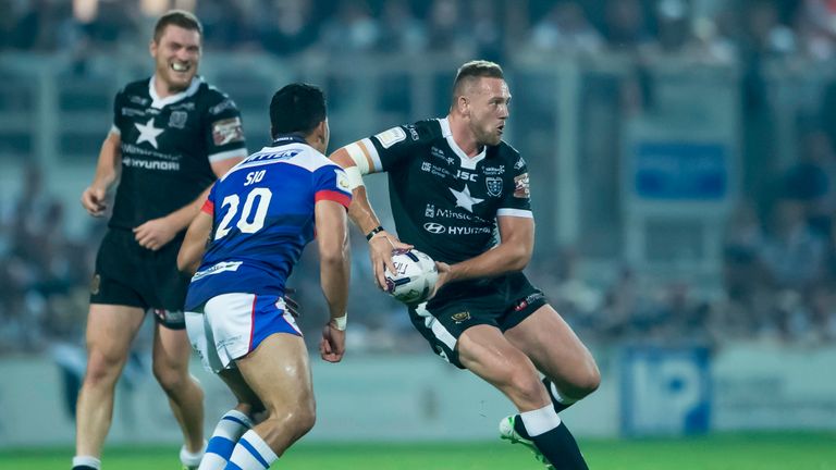 Hull FC's Liam Watts prepares to pass as Wakefield's Mickey Sio closes in.