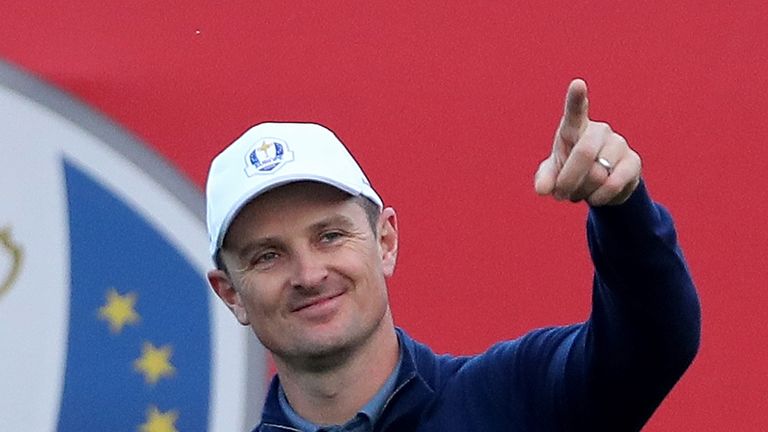 Rose gestures to the crowd on the first tee at Hazeltine