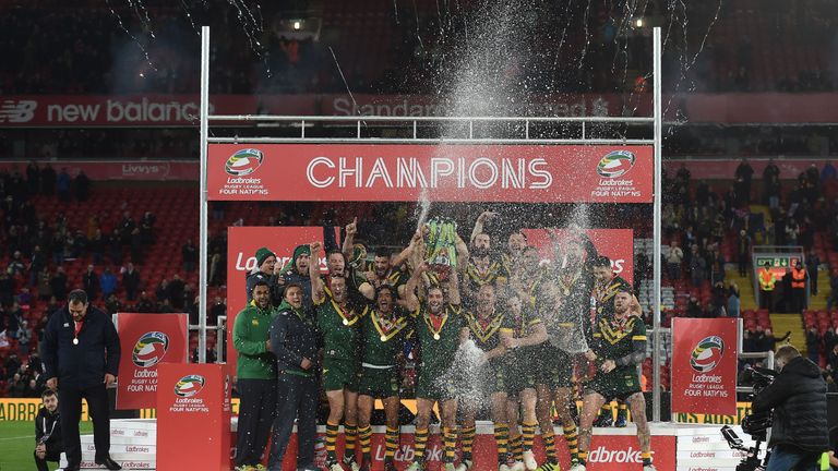 Australia's hooker and captain Cameron Smith (C) holds the trophy after winnging the rugby league Four Nations Final 