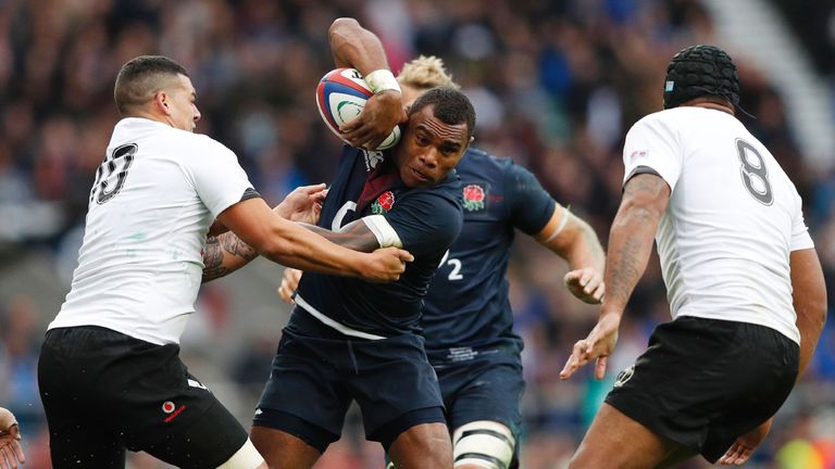 England's Semesa Rokoduguni (C) is tackled by Fiji's fly-half Josh Matavesi