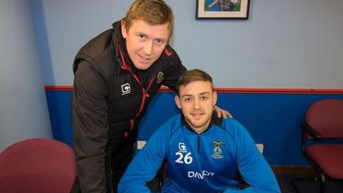 Image of Louis Laing puts pen to paper on a Inverness contract