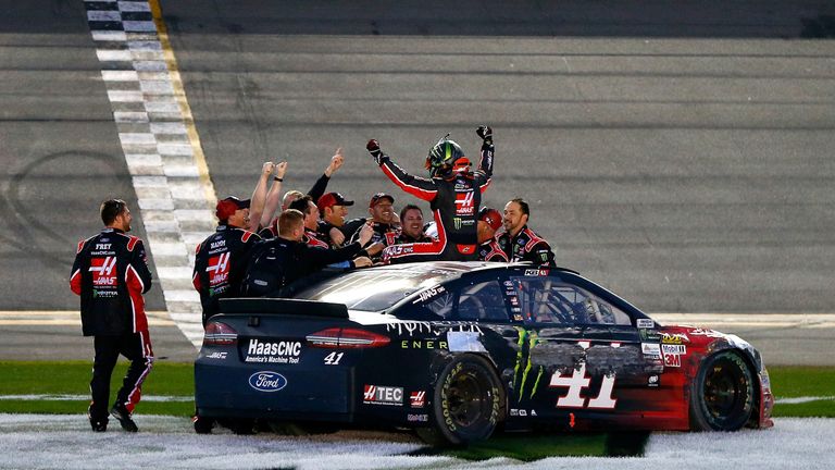 Kurt Busch clambers out of his damaged Ford to celebrate with the Stewart-Haas Racing team