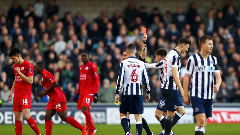 Jake Cooper of Millwall (CR) is shown a red card by referee Craig Pawson