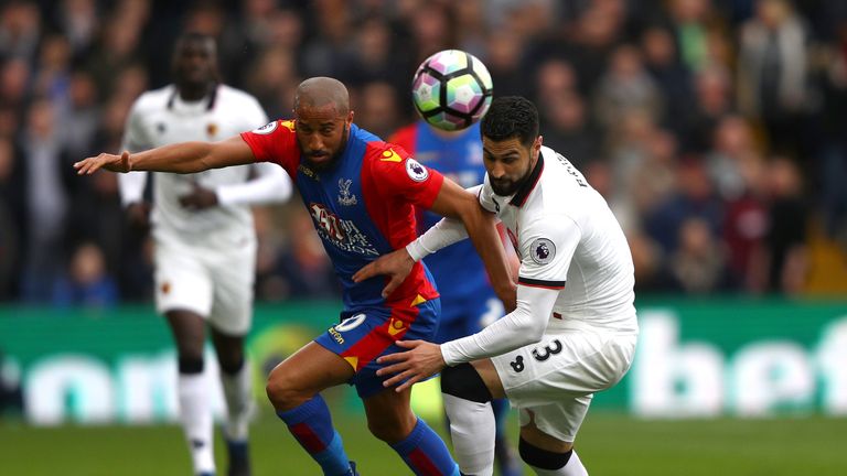 Andros Townsend (left) and Miguel Britos battle for possession
