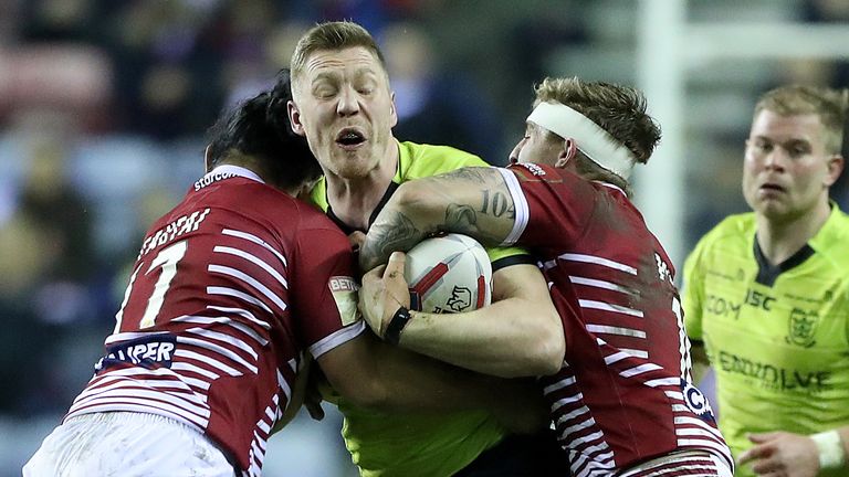 Hull FC's Chis Green is tackled by Wigan Warriors duo Taulima Tautai (left) and Sam Powell (right) 