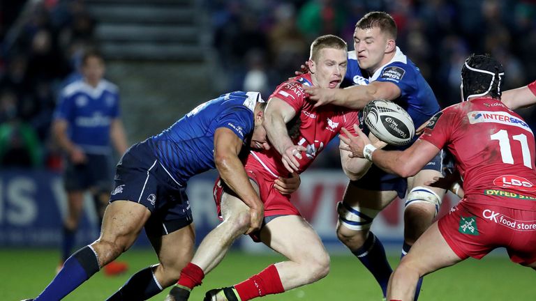 Adam Byrne and Ross Molony get to grips with Johnny McNicholl of Scarlets.