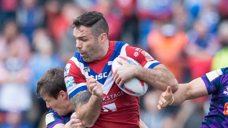 Wakefield's Anthony England is tackled by Wigan's Joel Tomkins.